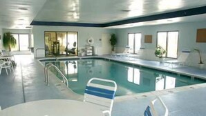Ein Hallenbad mit freier Sicht auf den Poolbereich, einschließlich Liegestühlen und der Poolkante.