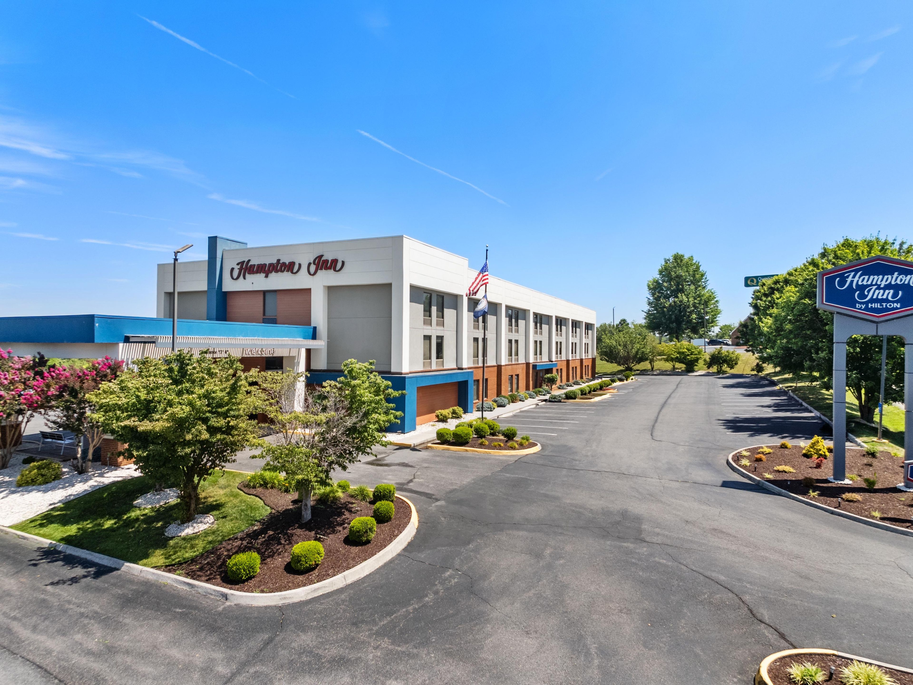 Un Hampton Inn de Hilton con estacionamiento y zonas ajardinadas.