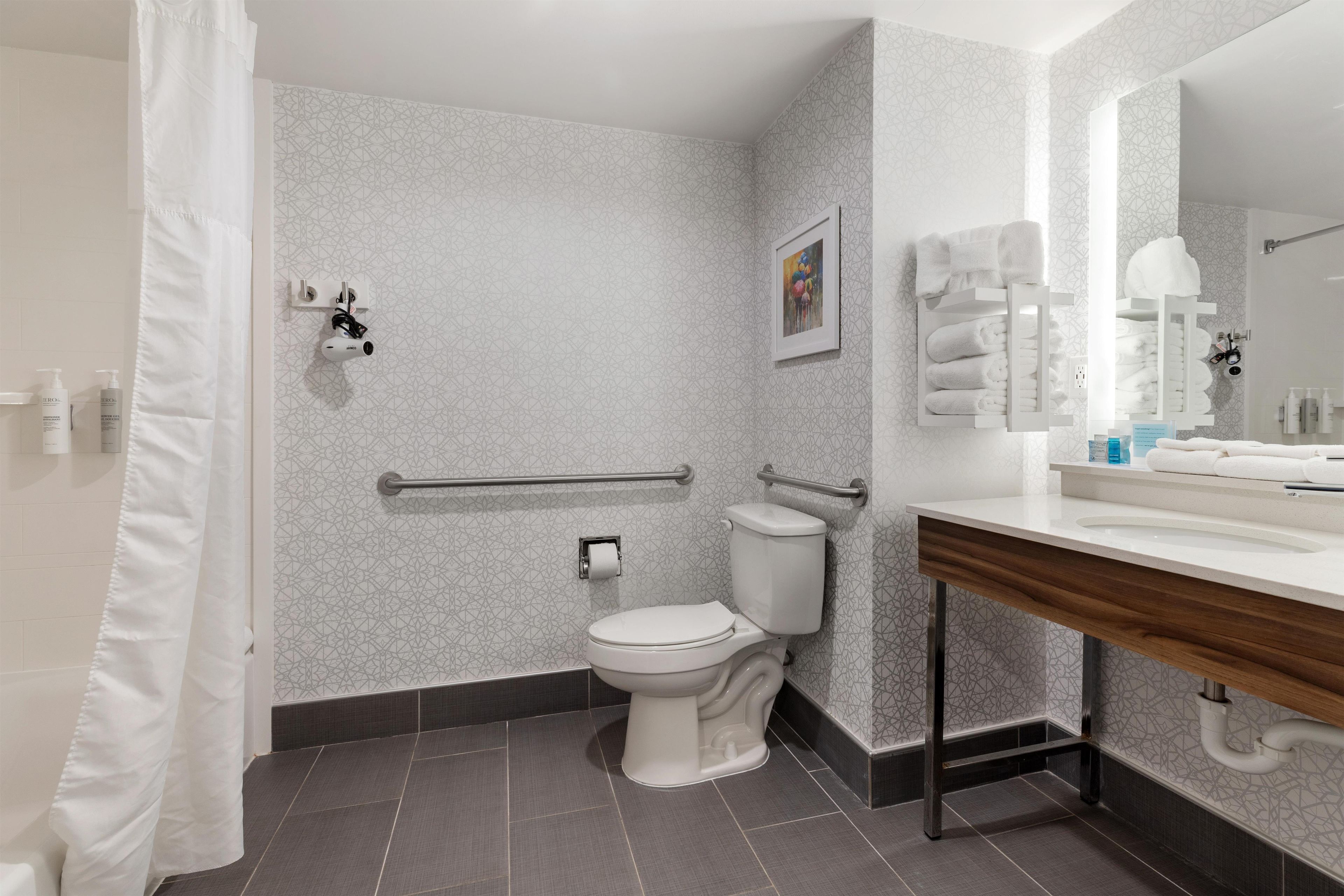 Un baño moderno con inodoro, ducha y tocador.