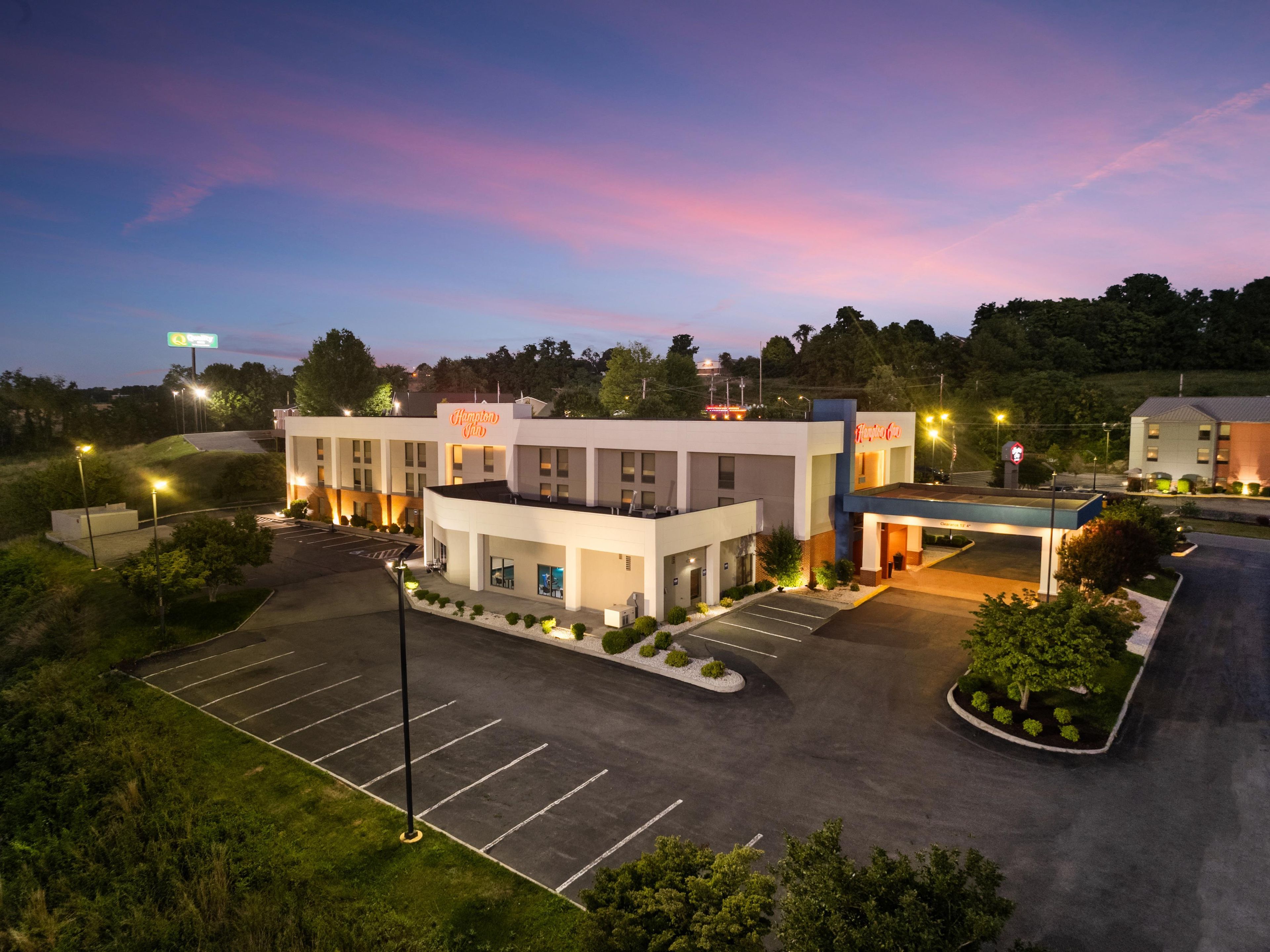 Un hotel con estacionamiento y un edificio con un letrero que dice 'Hampton Inn'.