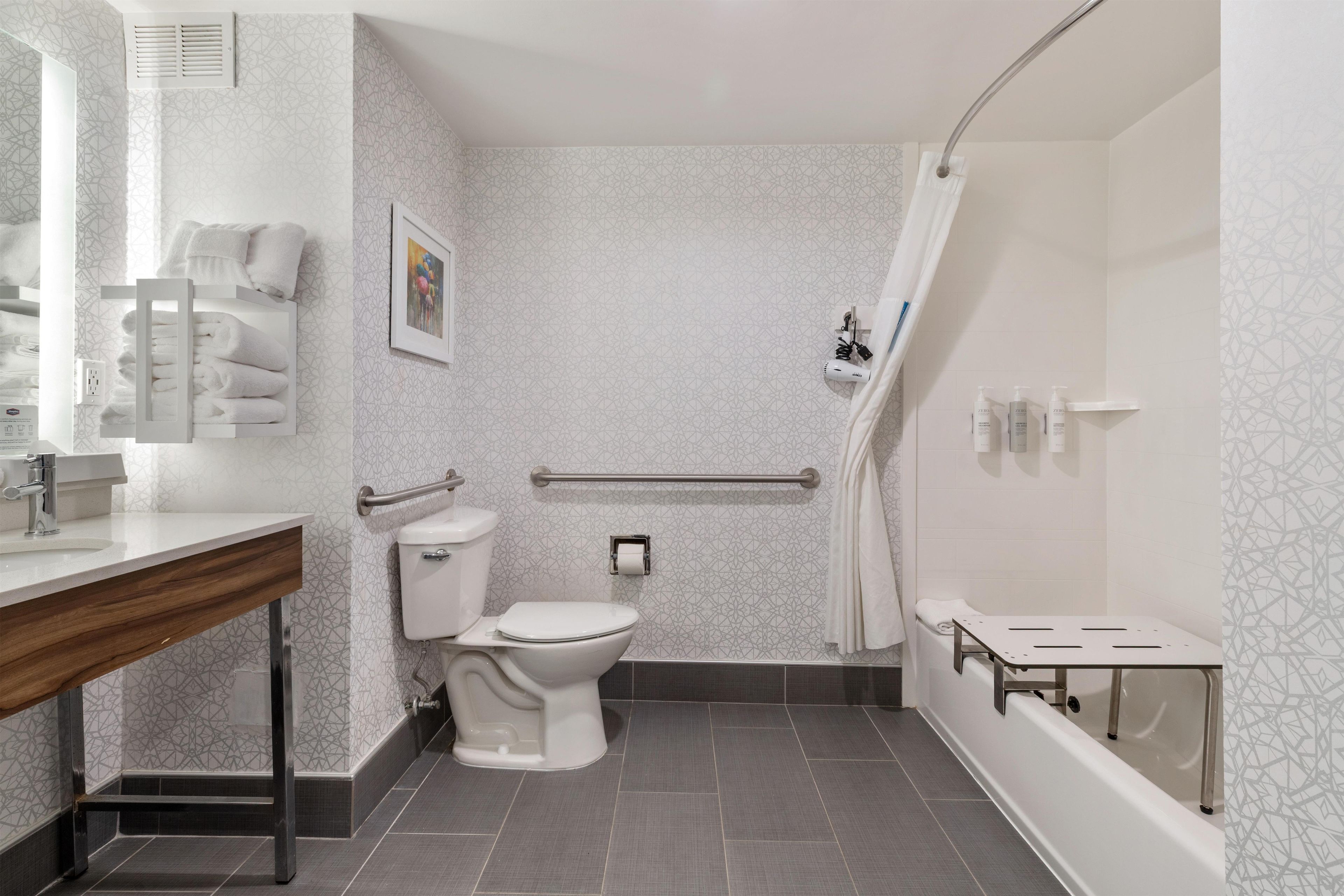 A modern bathroom with a toilet, sink, and shower area.