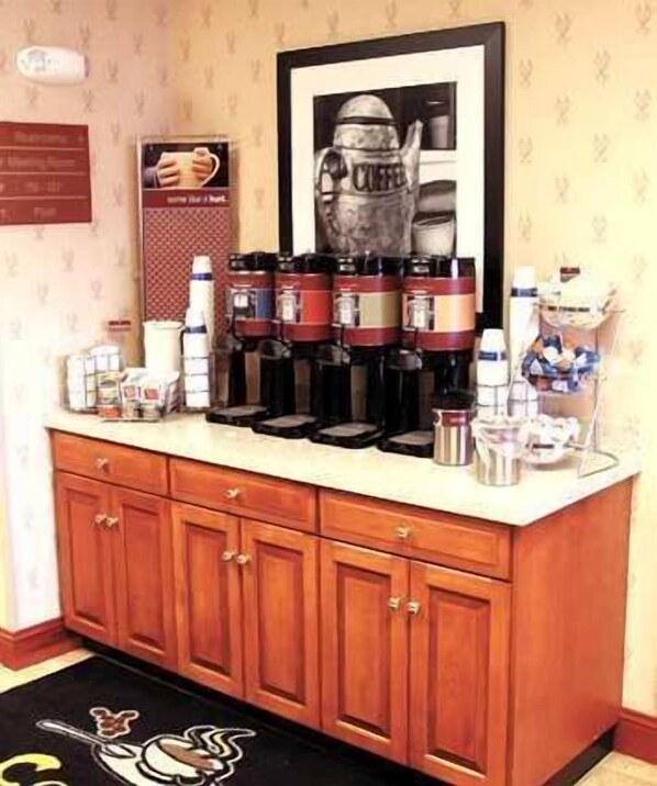 A kitchen area with a coffee station featuring multiple coffee makers and a coffee dispenser. - Hampton Inn Dublin (Dublin)