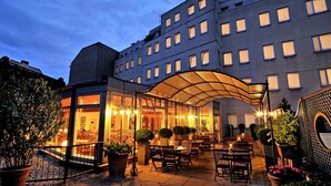 A hotel with a covered outdoor seating area, multiple floors, and a modern architectural design. - Hotel Ludwig van Beethoven (Berlin)