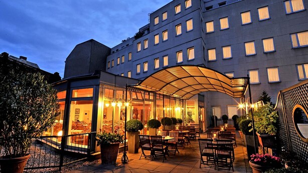 A hotel with a covered outdoor seating area, multiple floors, and a modern architectural design. - Hotel Ludwig van Beethoven (Berlin)