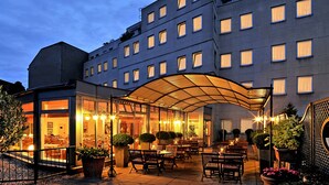 A hotel with a covered outdoor seating area, multiple windows, and a modern architectural design. - Hotel Ludwig van Beethoven (Berlin)