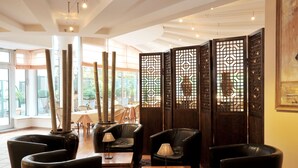 A modern interior with leather sofas, a wooden coffee table, and a decorative screen. - Hotel Ludwig van Beethoven (Berlin)