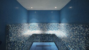 Una habitación con pared de azulejos y un banco.