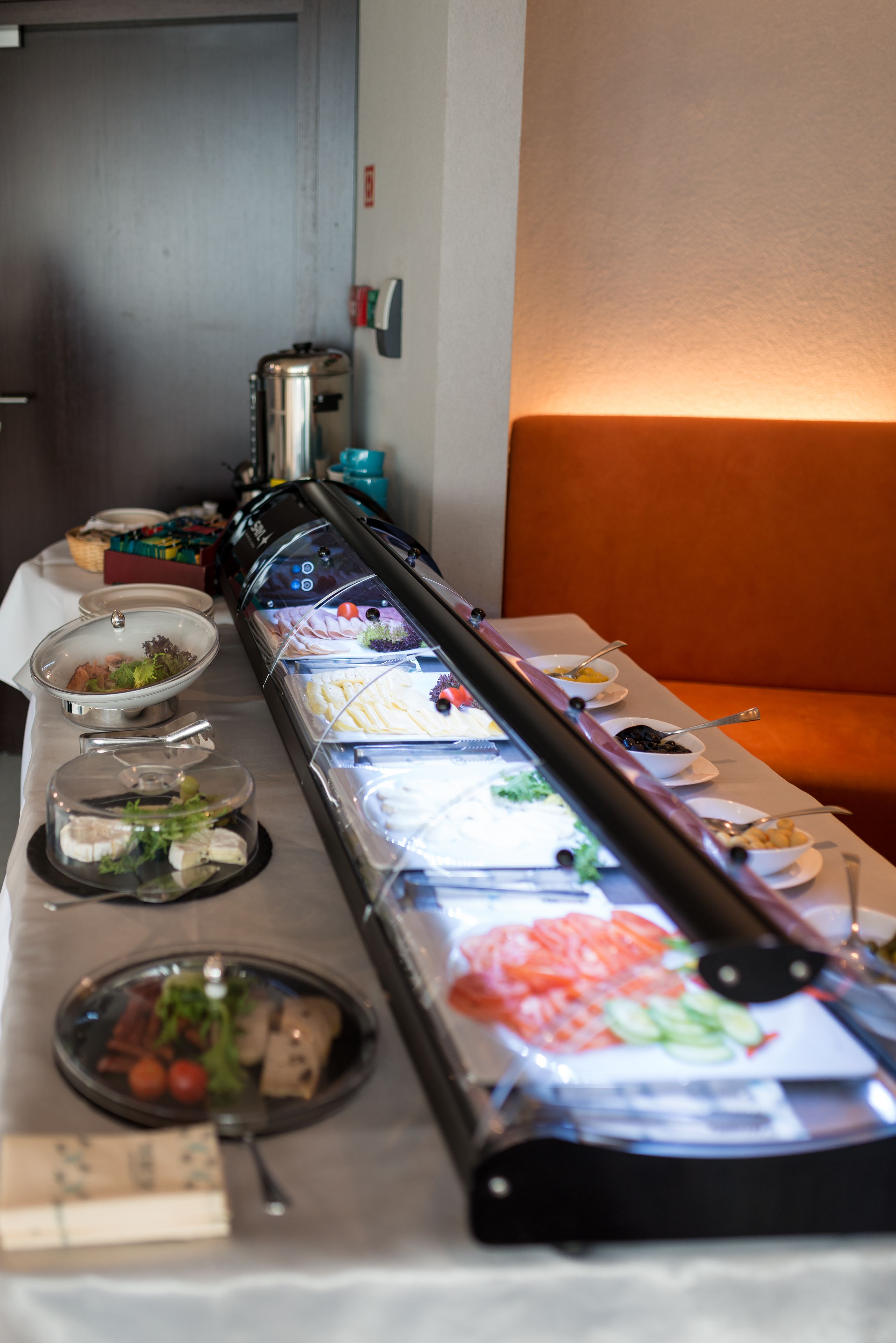 Een buffetopstelling met verschillende soorten eten, gepresenteerd in transparante bakken.