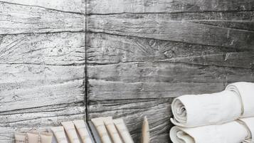 A bathroom with a wooden wall, a blue checkered floor, and neatly arranged toiletries and towels.