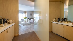 Una cocina moderna con espacio para café, un comedor con mesa y sillas, y una sala de estar con sofá y televisor.