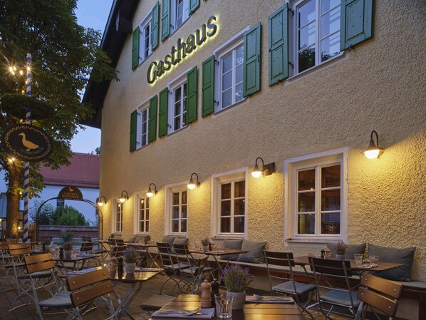 An outdoor seating area of a building with the name "Gasthof" on the facade. - Classik Hotel Martinshof (Munich)
