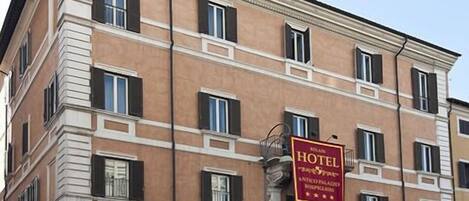 Ein mehrstöckiges Hotelgebäude mit einem auffälligen, roten Schild, das es als Hotel kennzeichnet.