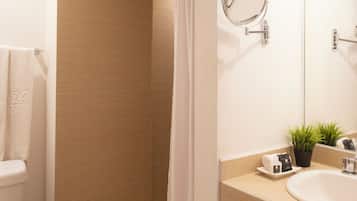 A modern bathroom with a toilet, a shower, and a sink.