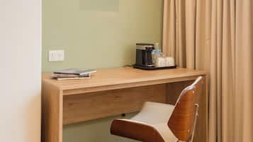 Un petit bureau privé comprenant un bureau, une chaise et une machine à café.
