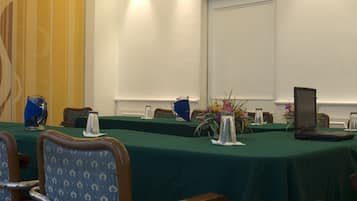A conference room with a long table, chairs, and a laptop.