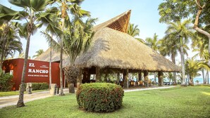 A thatched-roof building with a sign reading "EL RANCHO STEAK HOUSE & SEA FOOD". - Barceló Tambor (Paquera)