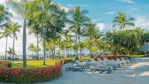 A resort with palm trees, lounge chairs, and a beach view. - Barceló Tambor (Paquera)