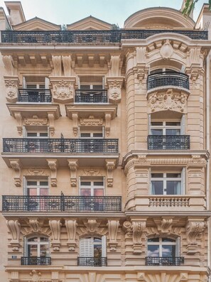 Un immeuble à plusieurs étages doté de détails architecturaux élaborés, notamment des colonnes, des balcons et des moulures décoratives.