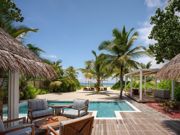 Relax by the spacious pool surrounded by lush greenery and comfortable lounge chairs.