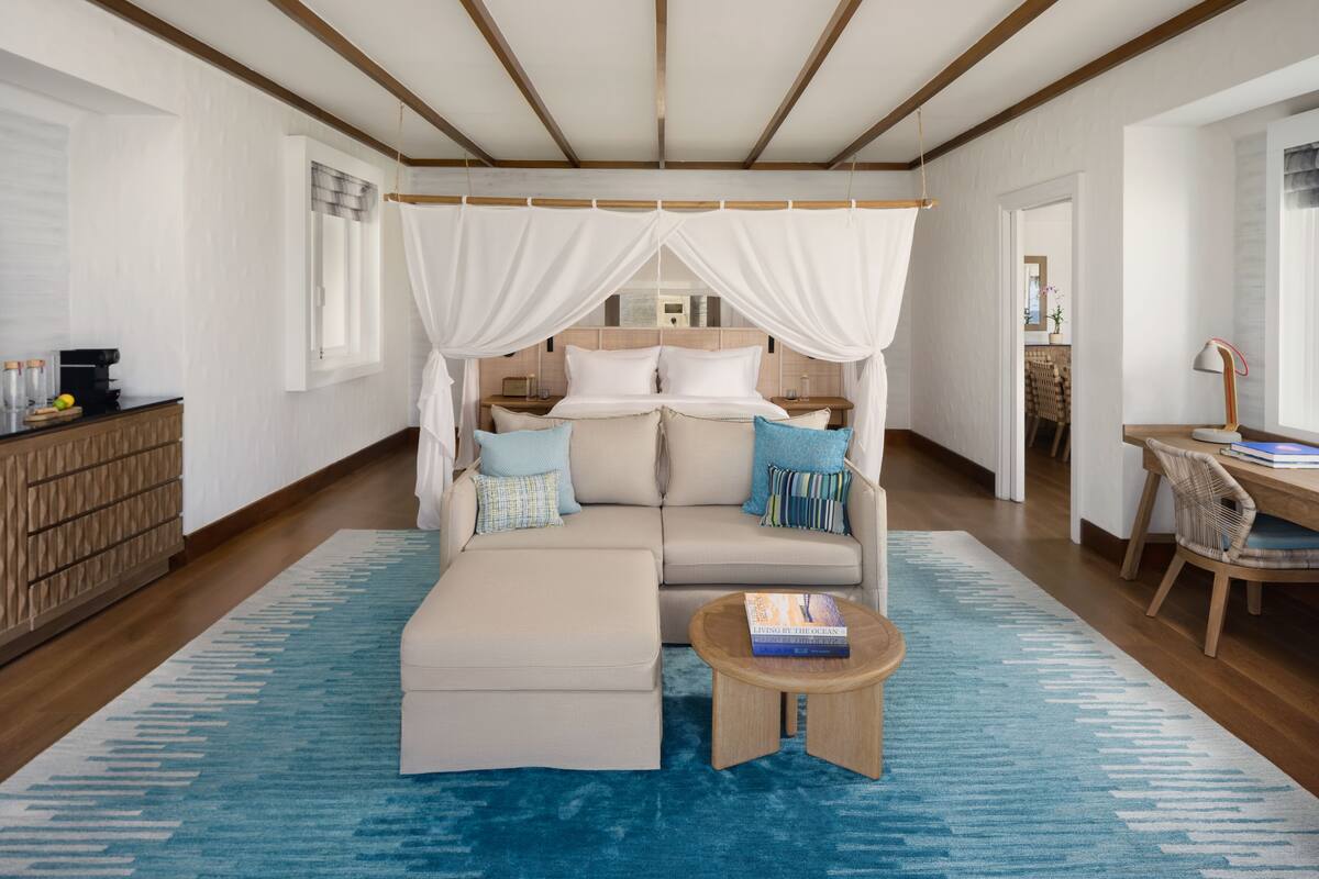Ein Schlafzimmer mit einem Bett, einem Sofa, einem Couchtisch und einem Schreibtisch mit Stuhl.