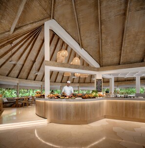 Enjoy fresh, locally sourced cuisine in our open-air dining area with a high ceiling and central serving counter.