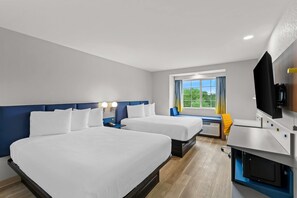 A hotel room with two beds, a TV, a desk, and a window with a view of greenery. - Microtel Inn & Suites by Wyndham Norcross (Norcross)