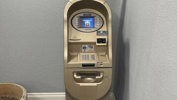 Un guichet automatique miniature, doté d’un écran, d’un lecteur de cartes et d’un distributeur de billets.