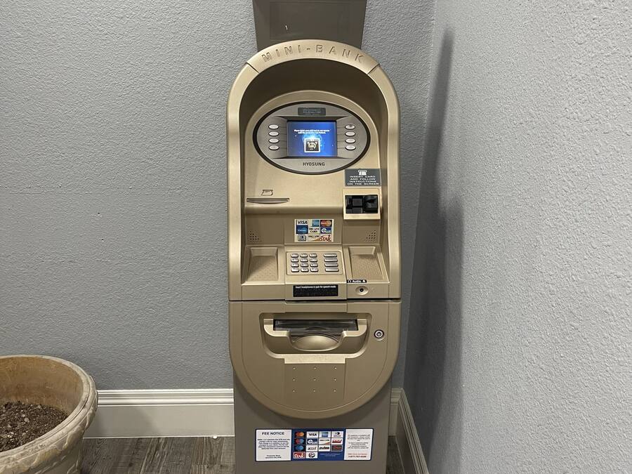 Un guichet automatique miniature, doté d’un écran, d’un lecteur de cartes et d’un distributeur de billets.