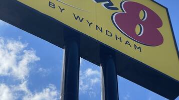 Placa de 'Super 8 by Wyndham' com um céu azul claro ao fundo.