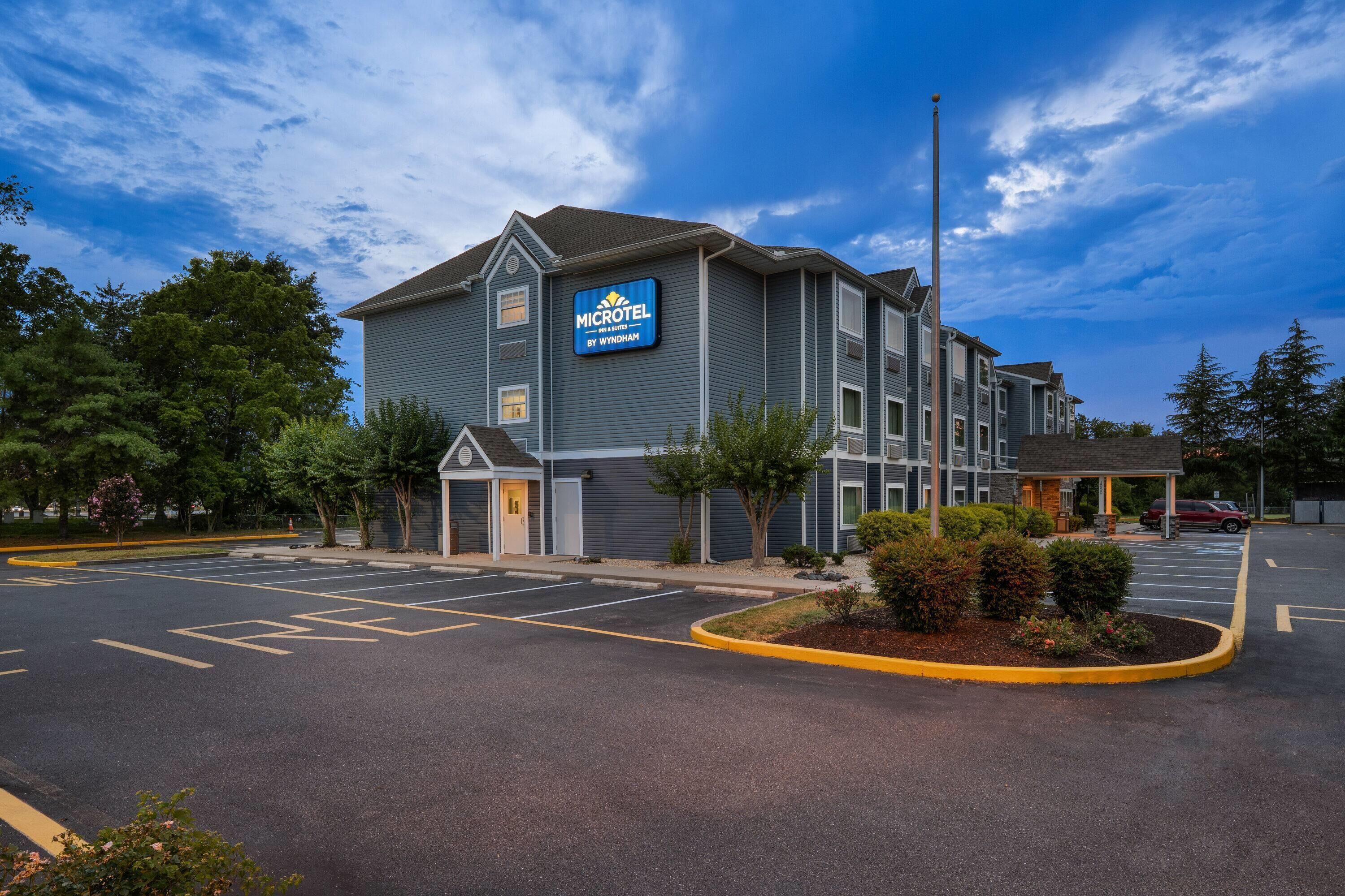 Un hotel Microtel con estacionamiento y cielo despejado.