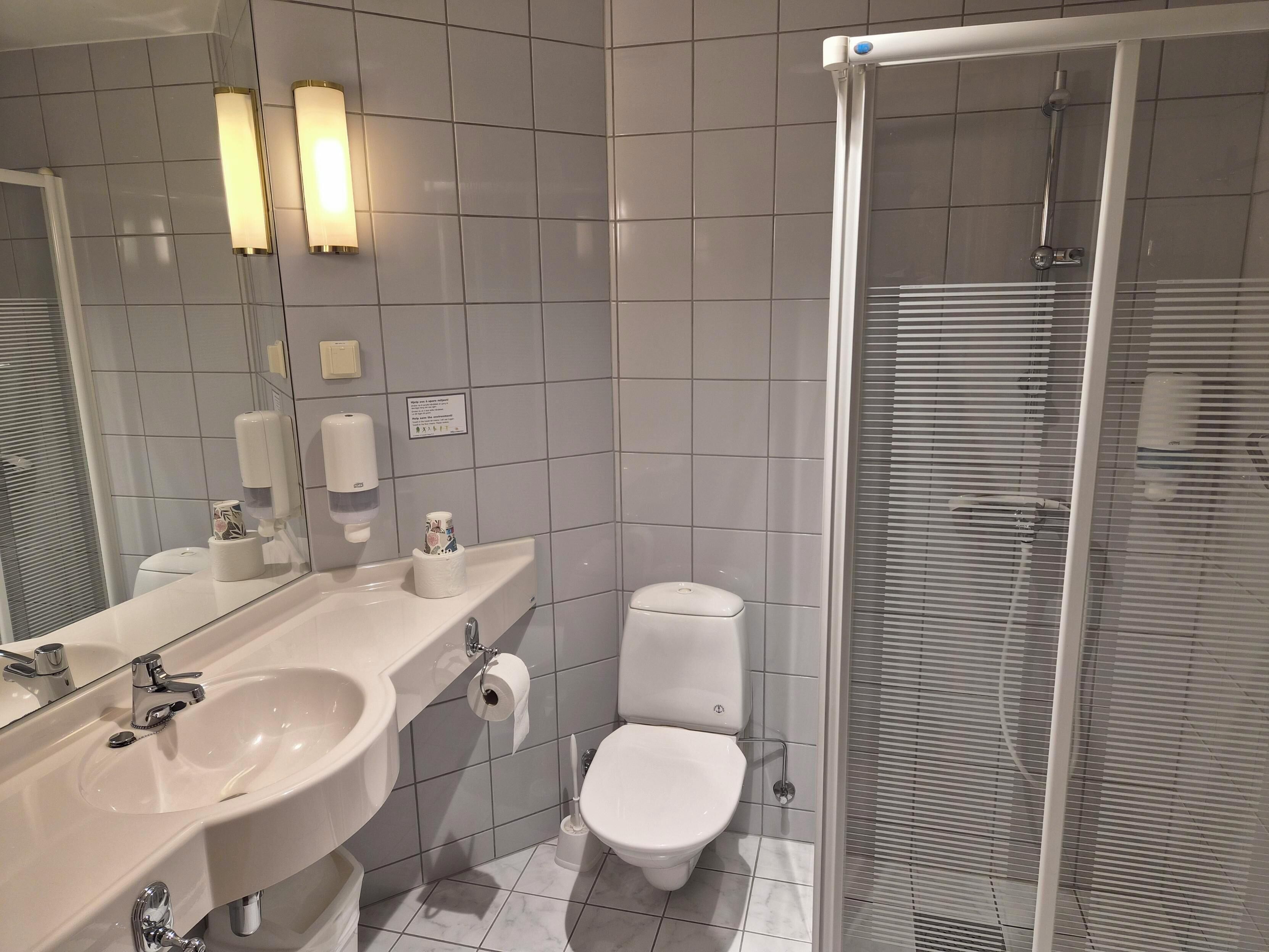 Kylpyhuone, jossa on pesuallas, wc ja suihku.