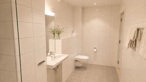 A modern bathroom with a white sink, toilet, and shower area. - Haukeland Hotell (Bergen)