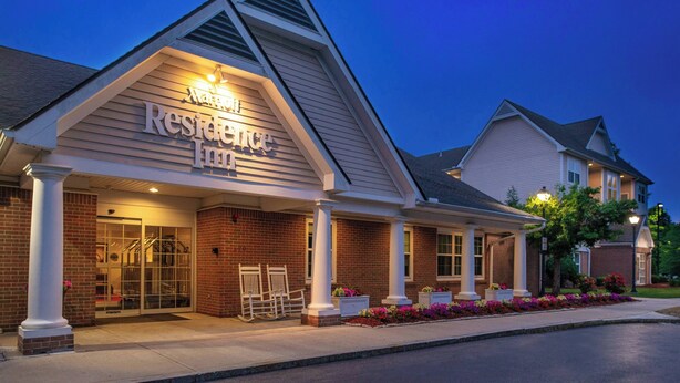 L’entrée d’un hôtel, avec une enseigne indiquant « Marriott Residence Inn », et un espace porche abrité.