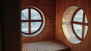A room with wooden walls and a bench, featuring two large circular windows with a cross design. - Clarion Hotel Örebro (Örebro)