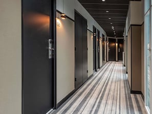 Ein Hotelgang mit den Nummern 106 und 102, Teppichböden und eingelassener Beleuchtung.