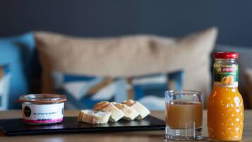 A breakfast setting with a jar of granini apricot, a glass of coffee, and a container of salmon rillettes on a tray.