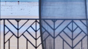 A beach view through a window with a geometric patterned blind. - Mercure St Malo Front De Mer (Saint-Malo)