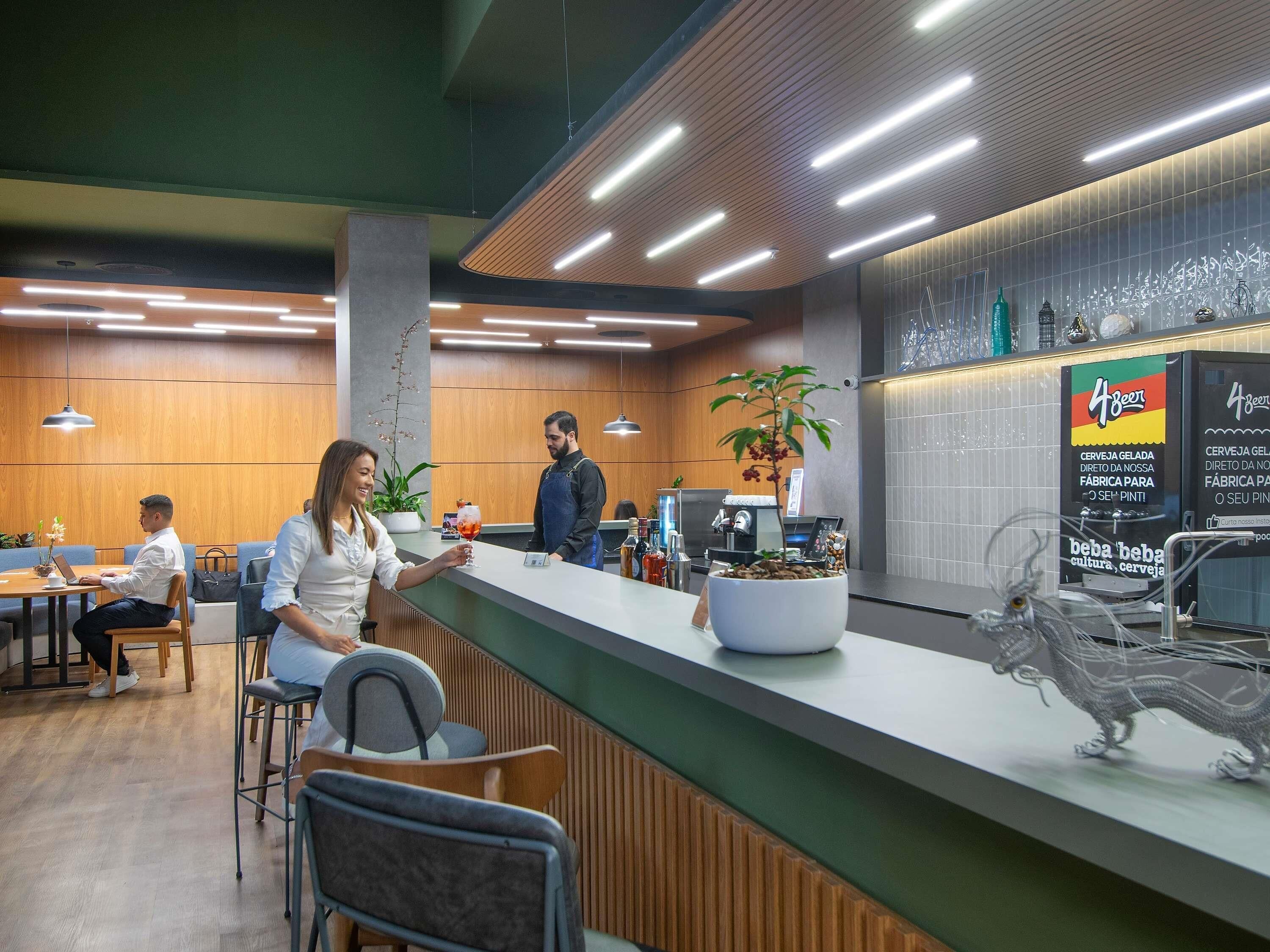 Un área de recepción moderna con mostrador, asientos y una planta decorativa.