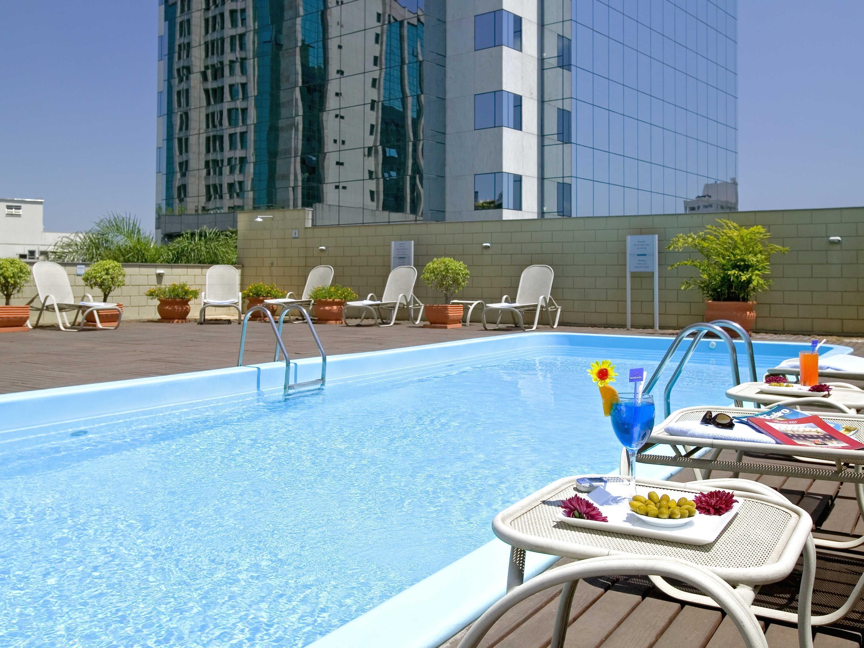 Una piscina al aire libre, sillones reclinables de piscina