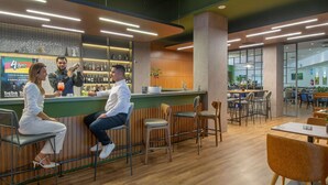 A modern bar area with wooden accents, a counter, and seating arrangements. - Novotel Porto Alegre Tres Figueiras Hotel (Porto Alegre)