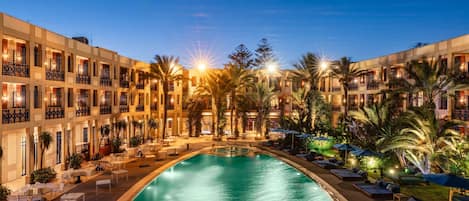 Una piscina al aire libre, sombrillas