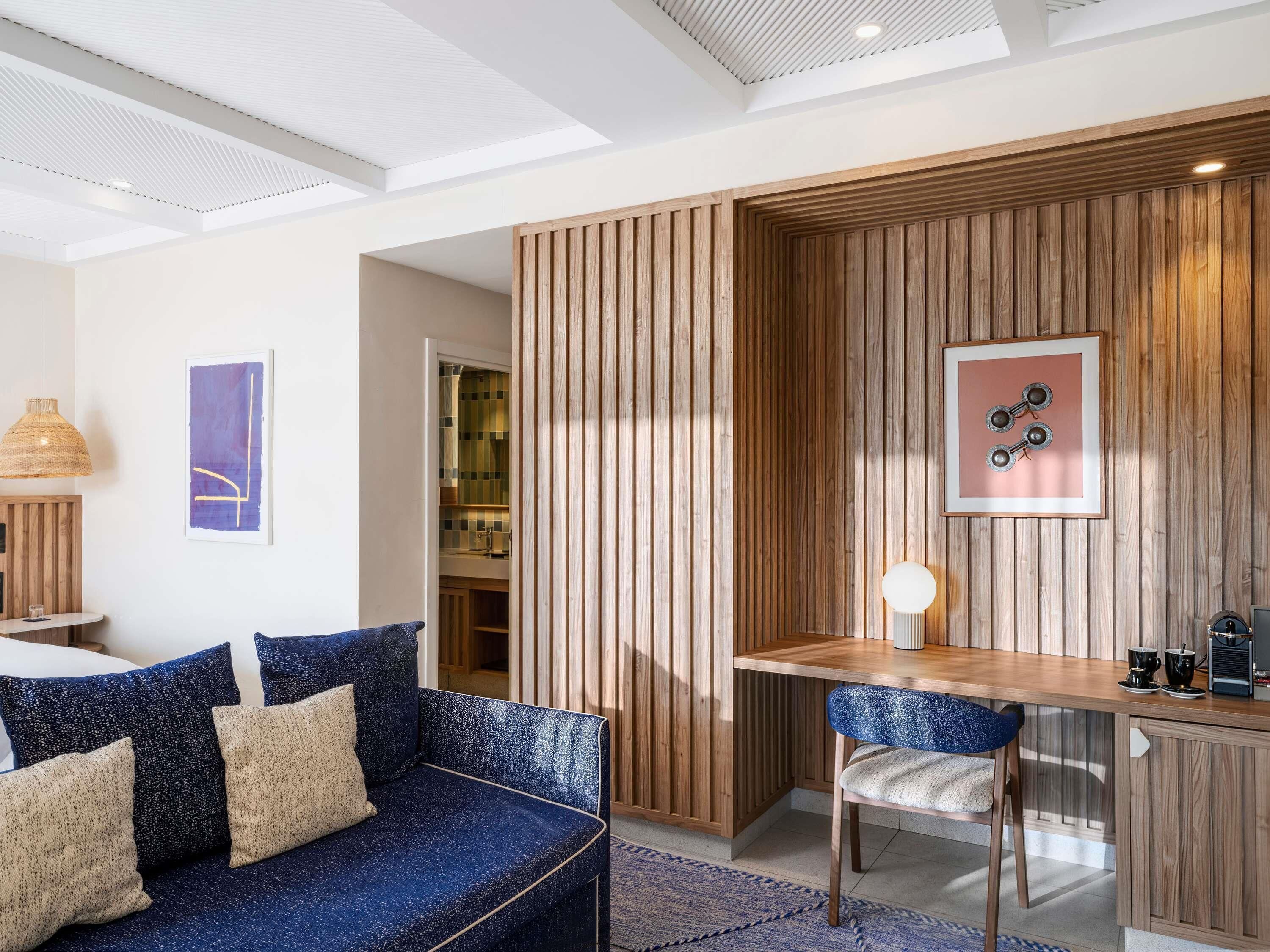 Una sala de estar moderna con un sofá, una mesa de comedor y una zona de cocina.