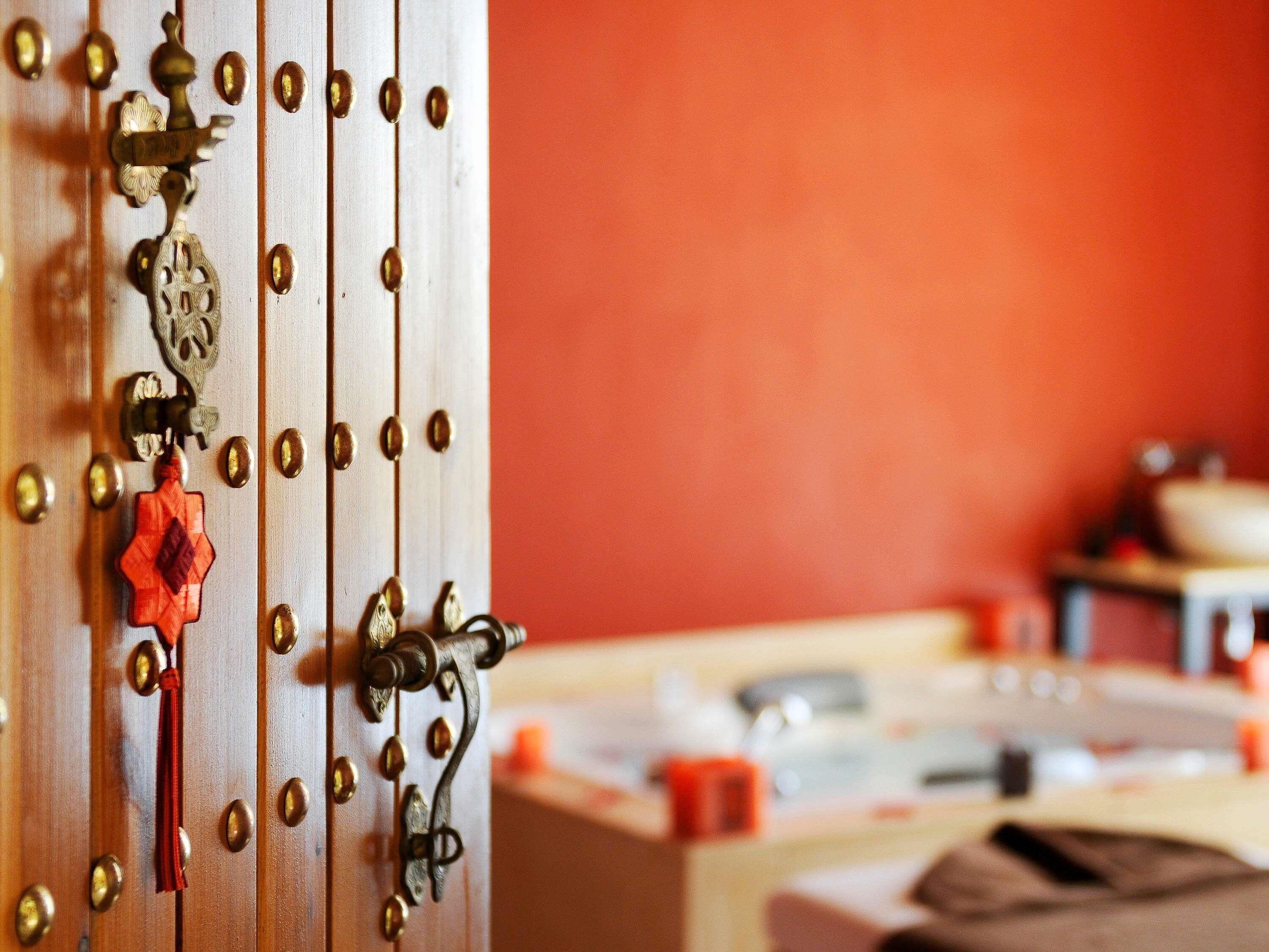 A close-up of a door with brass hardware, a red tassel, and a decorative keyhole.