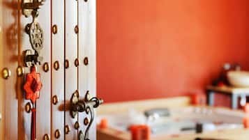 A close-up of a door with brass hardware, a red tassel, and a decorative keyhole.