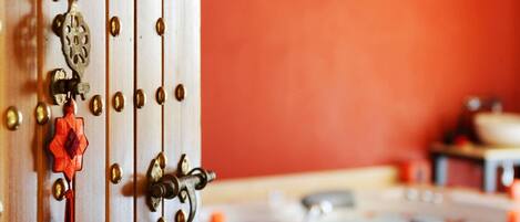 A close-up of a door with brass hardware, a red tassel, and a decorative keyhole.