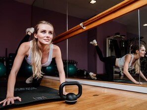 A gym with exercise equipment, a large mirror, and a wooden floor. - Le Médina Essaouira Thalassa Sea & Spa - MGallery Collection (Essaouira)