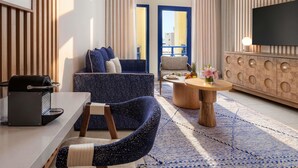 A modern living room with a sofa, armchair, coffee table, and a flat-screen TV. - Le Médina Essaouira Thalassa Sea  & Spa - MGallery Collection (Essaouira)
