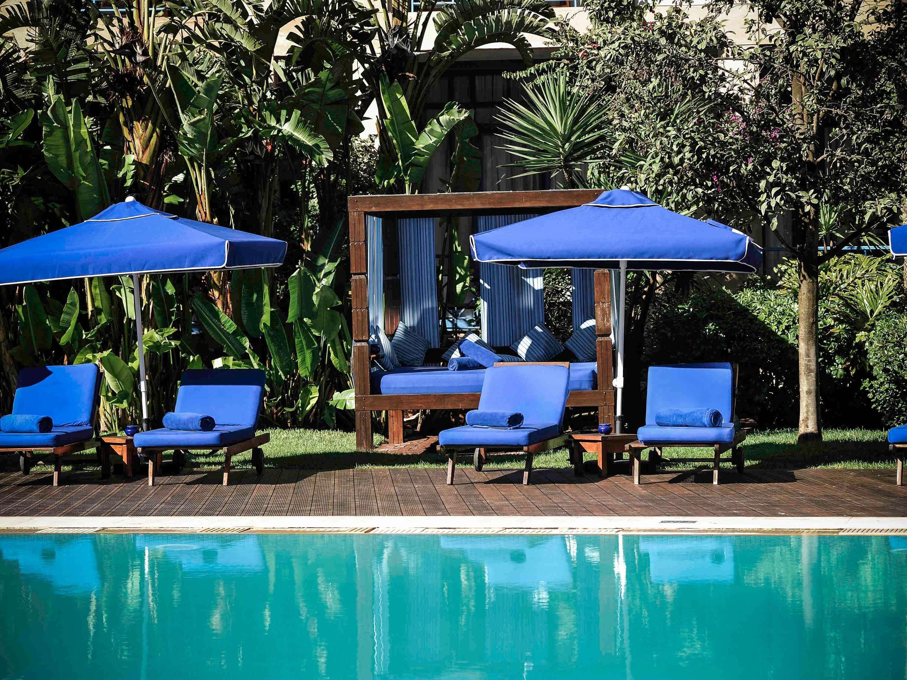 Una piscina al aire libre, sombrillas