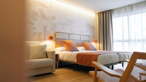 Una habitación de hotel moderna con una cama, un sofá y una silla.