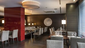 A modern restaurant with a central dining area, multiple tables, and chairs. - Hotel Zenit Barcelona (Barcelona)